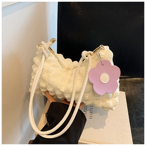 Detail of white bubble texture shoulder bag with purple flower charm and popcorn pleats