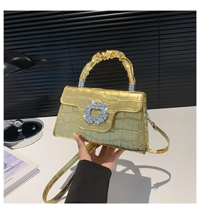Close-up of golden crocodile pattern handbag with luxury crystal buckle and pleated handle
