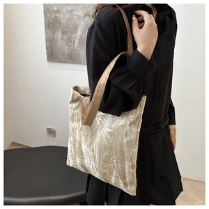 Champagne tote bag with bamboo patterns shown on a model in a minimalist home setting