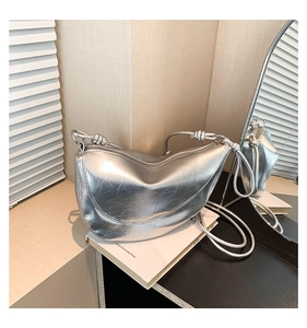 Detail of silver metallic dumpling bag with crinkled texture and knotted strap design