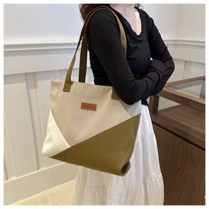 Detail of color-block canvas tote bag worn by model showing large capacity design