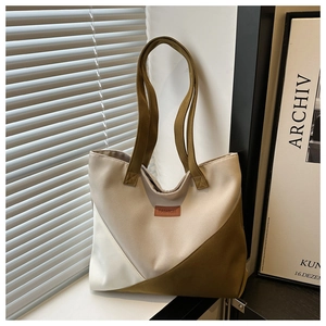 Detail of multi-color canvas tote bag featuring geometric V-shape stitching and leather label