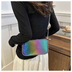Detail of iridescent holographic handbag with silver beaded edges and fine chain strap