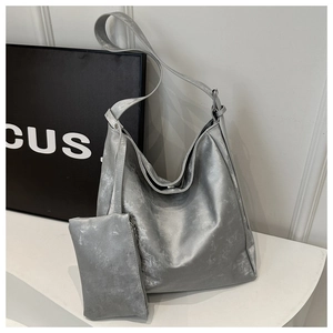Detail of silver metallic tote bag with distressed texture and matching pouch