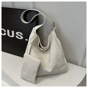 Close-up of a minimalist cream white tote bag set with matching pouch and silver rings