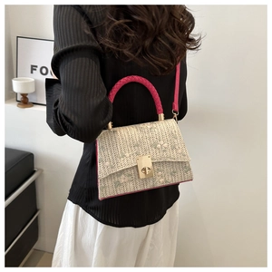 Détail des broderies florales et du fermoir doré sur le sac bandoulière tissé