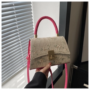 Gros plan du sac en paille tressée avec broderie florale et anse rose vif élégante