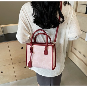 Vue mannequin d'un sac cabas rose avec poignées rouges et bandoulière amovible