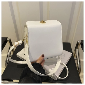 Vue détaillée d'un sac bandoulière blanc carré avec élégant fermoir rotatif en métal doré