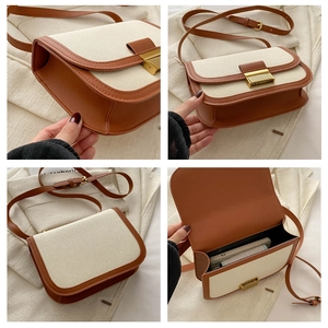 Detail view of a retro canvas and brown leather crossbody bag with a gold metal clasp
