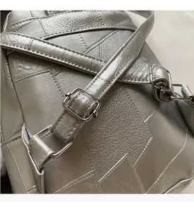 Detail der silbernen Metallic-PU-Lederstruktur und glänzenden Metallteile am Rucksack