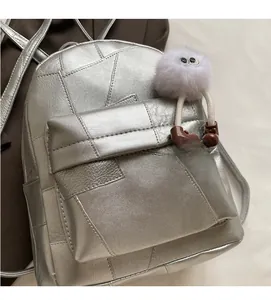 Nahaufnahme des silbernen geometrischen Rucksacks mit Metallic-Struktur und Plüschtier