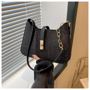 Détail du sac croissant à paillettes noires avec texture brillante et chaîne dorée