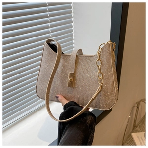 Détail du sac de soirée pailleté or champagne avec fermoir métallique et chaîne
