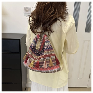 Detail of bohemian tote bag with geometric patterns and colorful hanging tassels