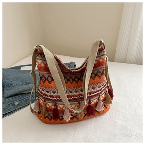 Detail of bohemian tote bag with geometric patterns and multi-colored fringe tassels
