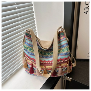 Detail of bohemian tote bag featuring colorful woven patterns and vibrant tassels