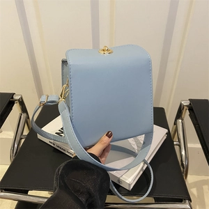 Sac bandoulière carré bleu clair avec fermoir doré, design urbain minimaliste élégant