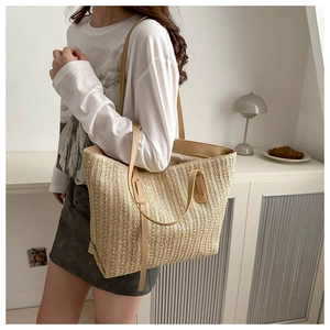 Detail of hand-woven straw tote bag with premium leather handles and natural texture