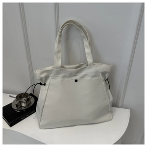 Close-up of white minimalist tote bag showing matte texture and black drawstring details