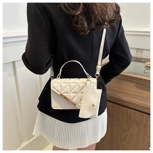 Detail of white quilted handbag set with elegant triangular stitching and small coin purse