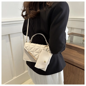 Detail of white quilted crossbody bag with golden metal bar and detachable coin purse