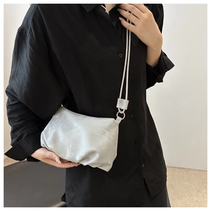 Détail du sac nuage argenté plissé avec anneau métallique et texture de tissu brillant