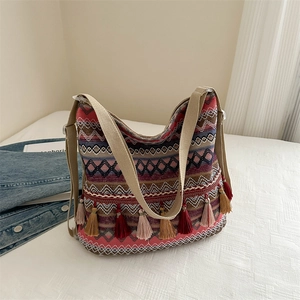 Ethnic knit tote bag with bohemian geometric patterns and colorful tassel charms
