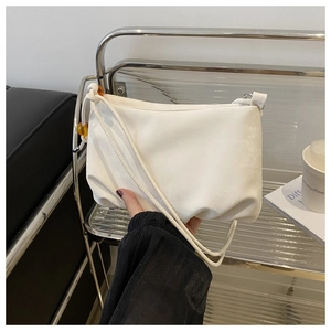 Détail du sac à main blanc plissé avec perles ambrées et texture en similicuir