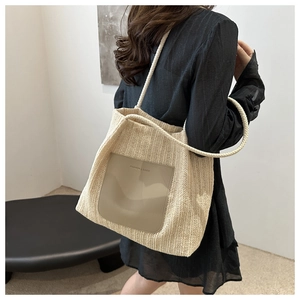 Straw tote bag detail with PU patch and rope handles shown on a model for summer