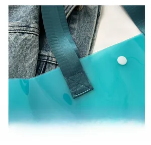 Detail of dark teal transparent tote with reinforced stitching and nylon strap