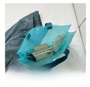 Top view of transparent blue PVC tote bag showing large capacity with personal items