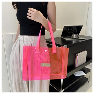 Neon pink transparent PVC tote bag with sturdy handles and a small brand patch detail