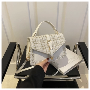 Detail of tweed crossbody bag with gold hardware and white faux leather trim texture