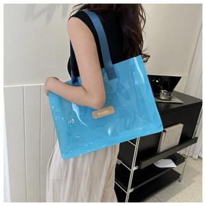 Detail of blue transparent waterproof PVC tote bag showing the textured shoulder strap