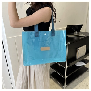 Blue semi-transparent waterproof tote bag with woven handles and leather detail
