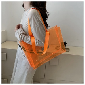 Detailed view of large orange transparent waterproof PVC tote bag for travel storage
