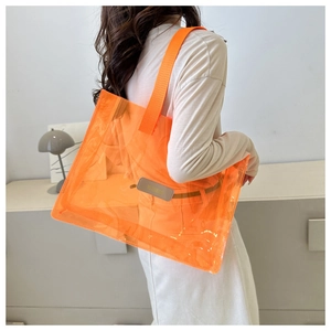 Close-up of orange transparent waterproof PVC tote bag with leather logo patch detail