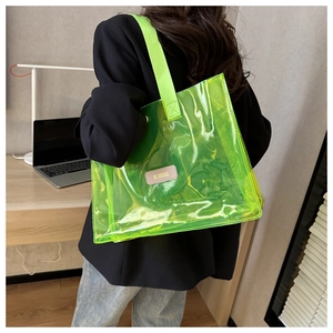 Detail of neon green transparent tote bag with durable nylon handles and branded leather patch