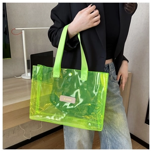 Fluorescent green PVC tote bag detail with wide fabric handles and leather logo patch