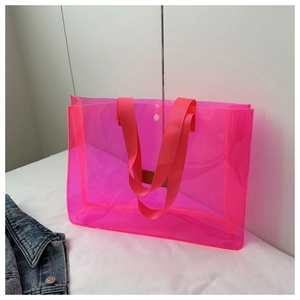 Detail of neon pink transparent tote bag with durable fabric handles and snap button closure