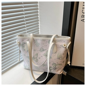 Détail du sac cabas lavande avec motifs de papillons verts et fine bandoulière blanche