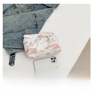 Vue détaillée de dessus de la trousse de toilette blanche avec motif paysage rose et mobile