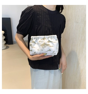 Detail of a white nylon cloud clutch bag with green ink landscape bamboo patterns