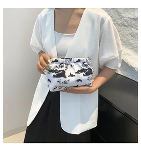 Detail of Chinese ink painting style clutch bag with cloud pleats held by a model