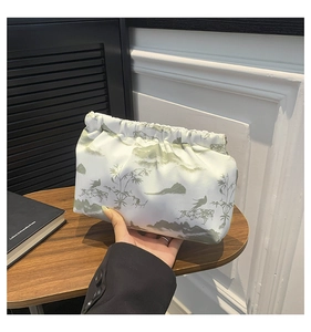 Detail of white cloth pouch showing green Chinese ink landscape painting and bamboo