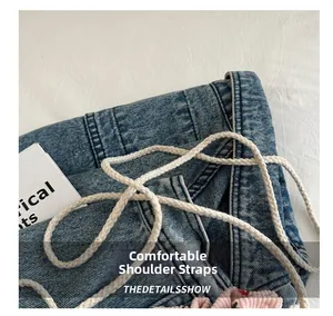Gros plan du sac seau en denim avec bandoulière en coton tressé blanc et détail en velours rose