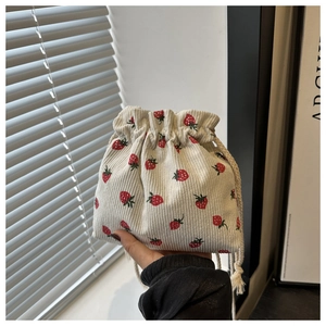 Détail d'un mini sac à cordon en velours côtelé avec imprimé fraise et cordes