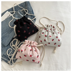 Detail of three corduroy bucket bags with strawberry prints and thick cotton rope straps