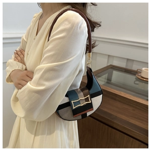 Detail of color-block patchwork underarm bag with gold buckle and slim round shoulder strap